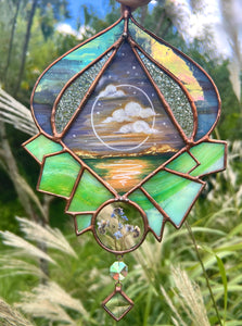 Gouache landscape set between glass with pressed forget-me-not flowers. Iridescent purple and textured clear glass border with green crystal formation. Hanging iridescent bevel and clear diamond glass bevel.